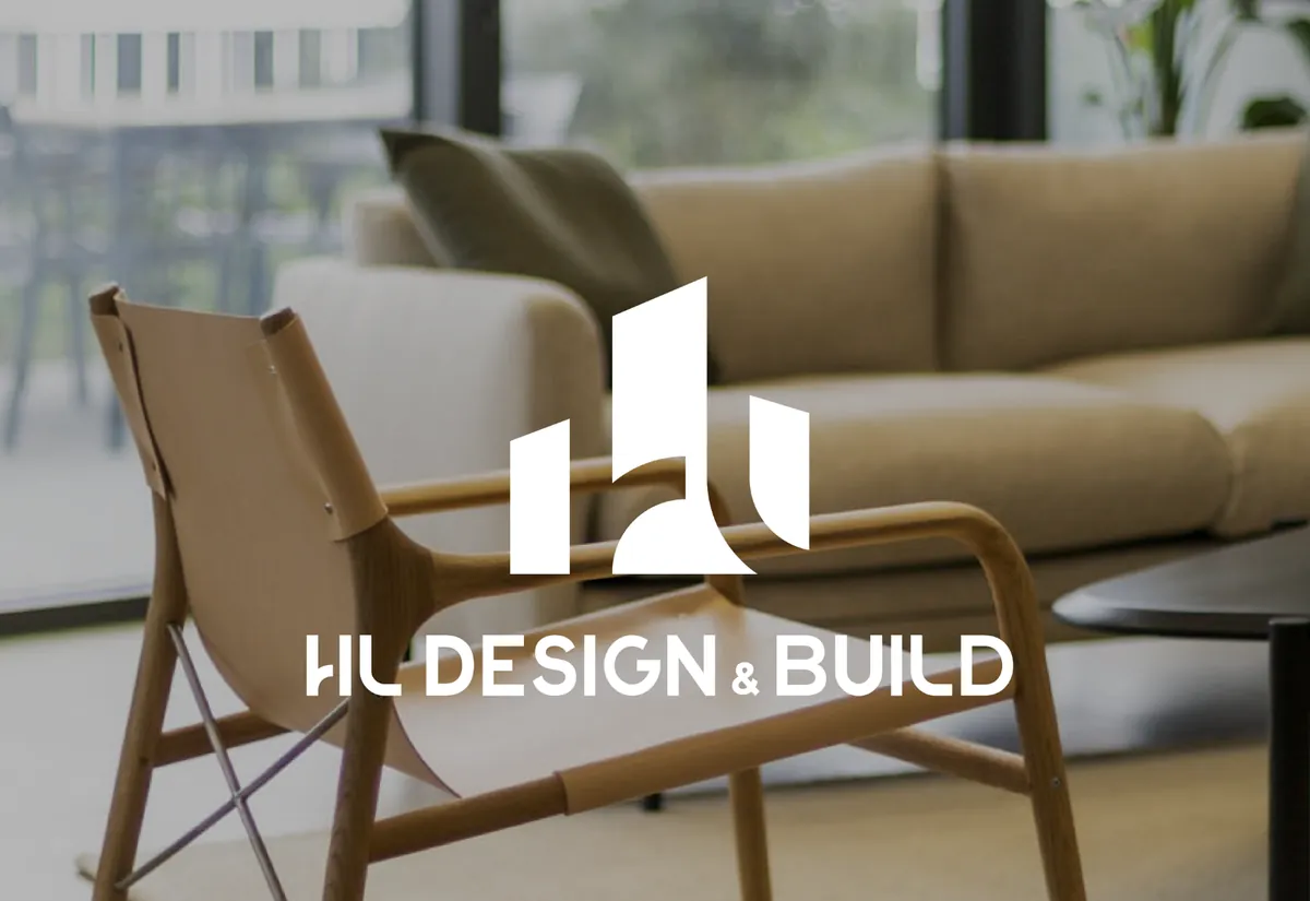 Logo HL Design & Build en blanc sur une photo de fauteuil et canapé dans un espace aménagé